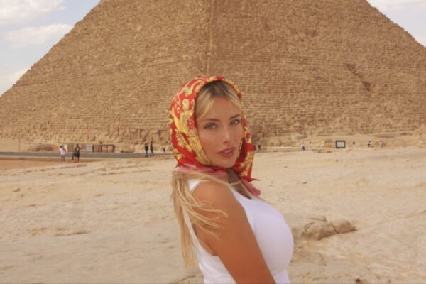 كورينا كوبف (Corinna Kopf) تذهل العالم بزيارتها الساحرة لأهرامات الجيزة في مصر Corinna Kopf كورينا كوبف تقف أمام الهرم الأكبر في الجيزة بمصر مرتدية وشاح رأس أحمر وأصفر وقميص أبيض وبنطال بيج.