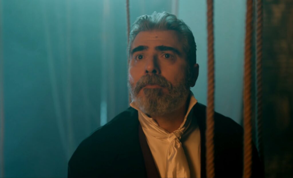 مشهد درامي من المسلسل يظهر فيه ممثل بملابس مسرحية وملامح صدمة خلف الحبال.