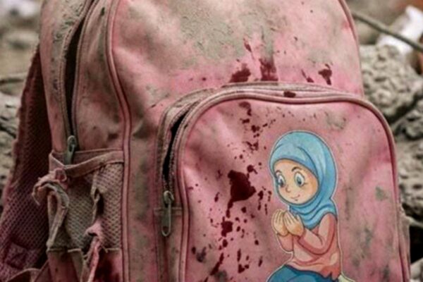 حقيبة مدرسية وردية مدمرة تحت الأنقاض تجسد مأساة مدرسة ميناب التي أدانتها منظمة اليونسكو كجريمة ضد التعليم في إيران.