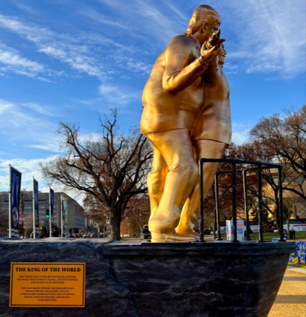 تمثال ذهبي يصور دونالد ترامب يعانق جيفري إبستين في وضعية فيلم تايتانيك فوق قاعدة تحاكي مقدمة سفينة بالمول الوطني في واشنطن.