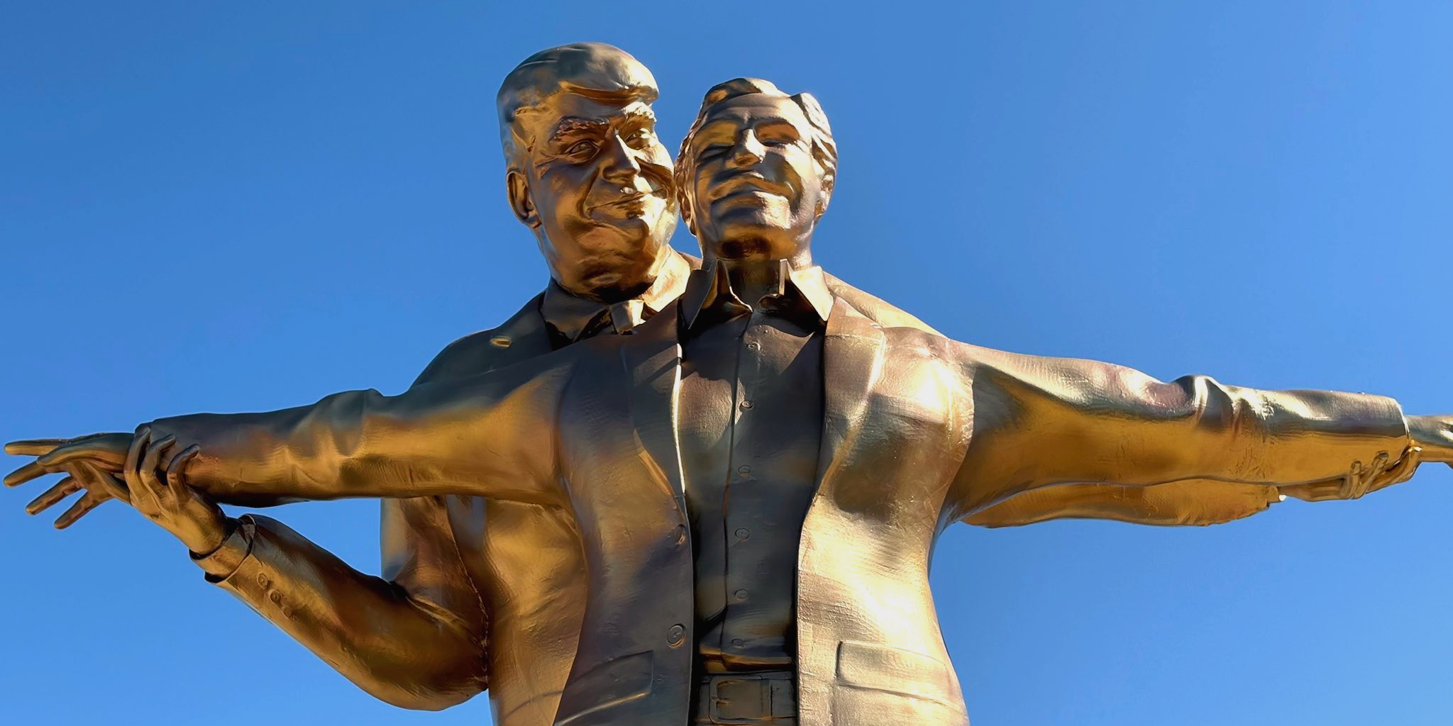 لقطة قريبة لـ تمثال ملك العالم الذهبي الذي يصور دونالد ترامب يعانق جيفري إبستين في وضعية فيلم تايتانيك الشهيرة تحت سماء واشنطن.