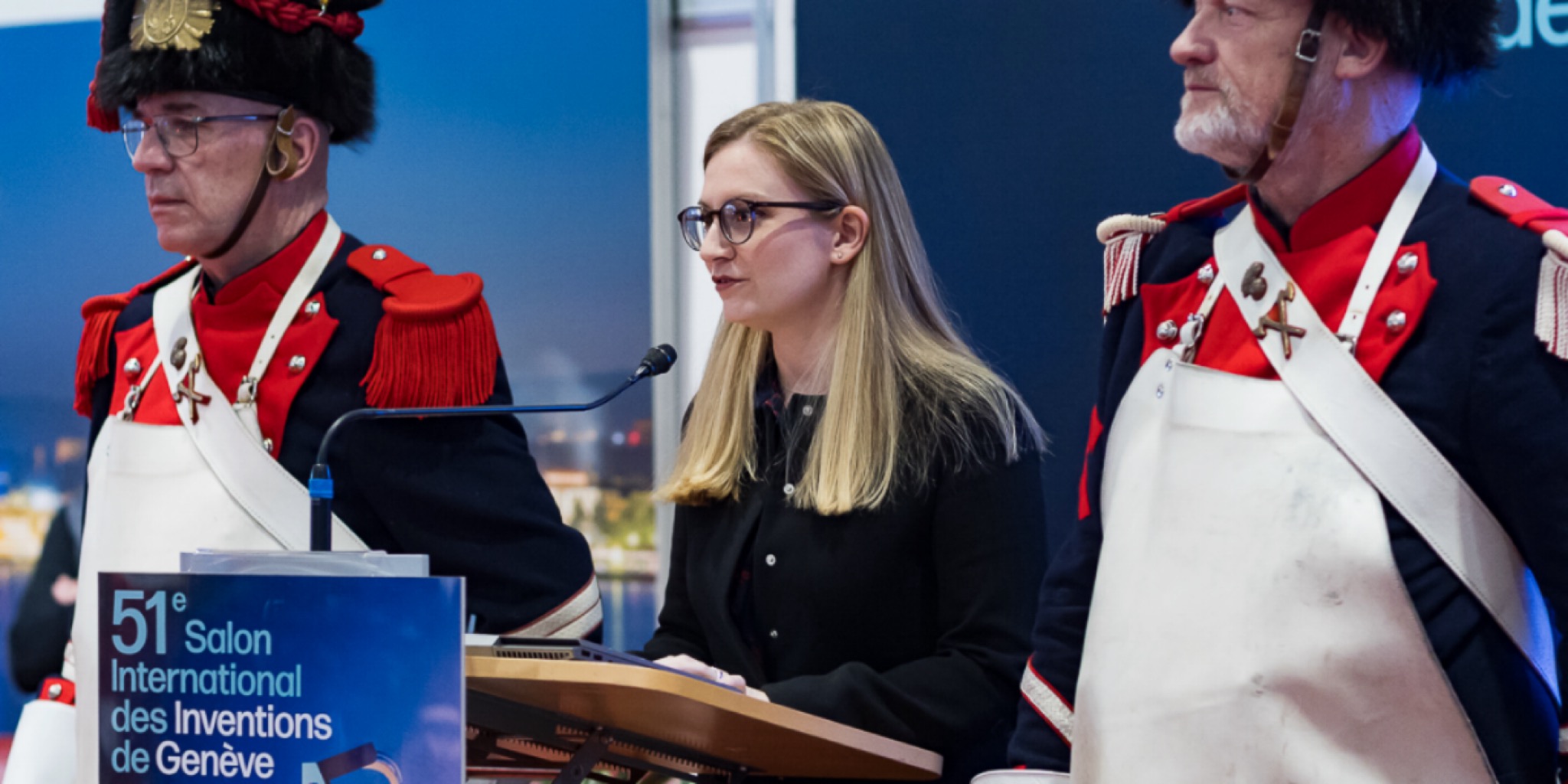 امرأة تلقي كلمة في الدورة 51 لمعرض جنيف الدولي للاختراعات بمركز باليكسبو بحضور الحرس التقليدي.