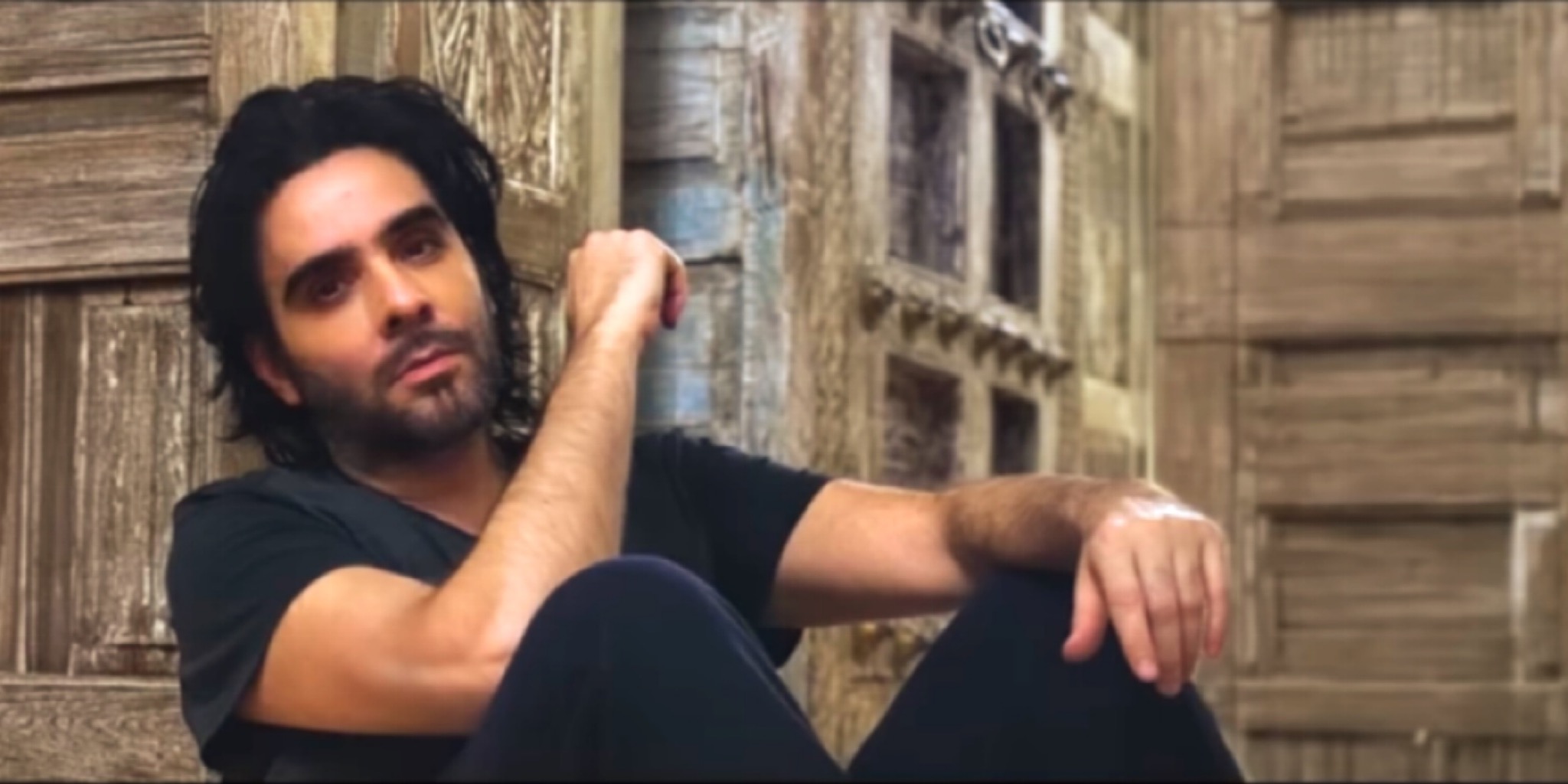 أغنية Canın Çıksın İnsafsız يظهر فيها الفنان إسماعيل يك بملامح حزينة أمام أبواب خشبية عتيقة تعكس كلاسيكية فن الأرابيسك.