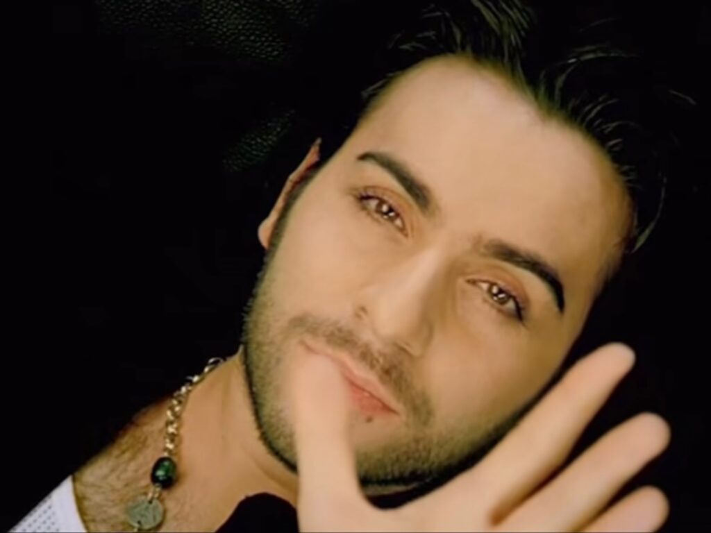 لقطة مقربة (Close-up) تبرز ملامح إسماعيل يك بنظرات مليئة بالشجن والأسى، تعكس عمق الانكسار الوجداني الذي يتناوله في أعماله الموسيقية الدرامية.