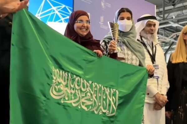 الجوهرة القحطاني ترفع العلم السعودي وتحمل كأس الجائزة الكبرى في معرض جنيف الدولي للاختراعات 2026.