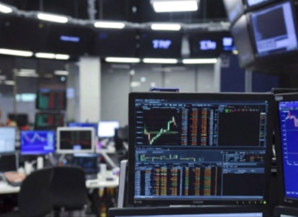 شاشات تداول أسهم تظهر مخططات السوق في الوقت الفعلي، مع تركيز على شاشة تظهر تراجعاً حاداً، لتصوير الأثر على الأسهم بعد إنهاء اتفاقية شركة INWIT وصدمة أسواق المال.