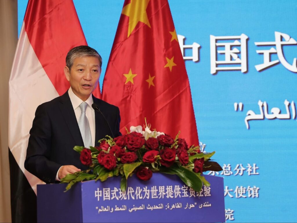  السفير الصيني يتحدث خلف المنصة أمام علمي مصر والصين في منتدى حوار القاهرة، صورة رسمية من صفحته الرسمية على فيسبوك.