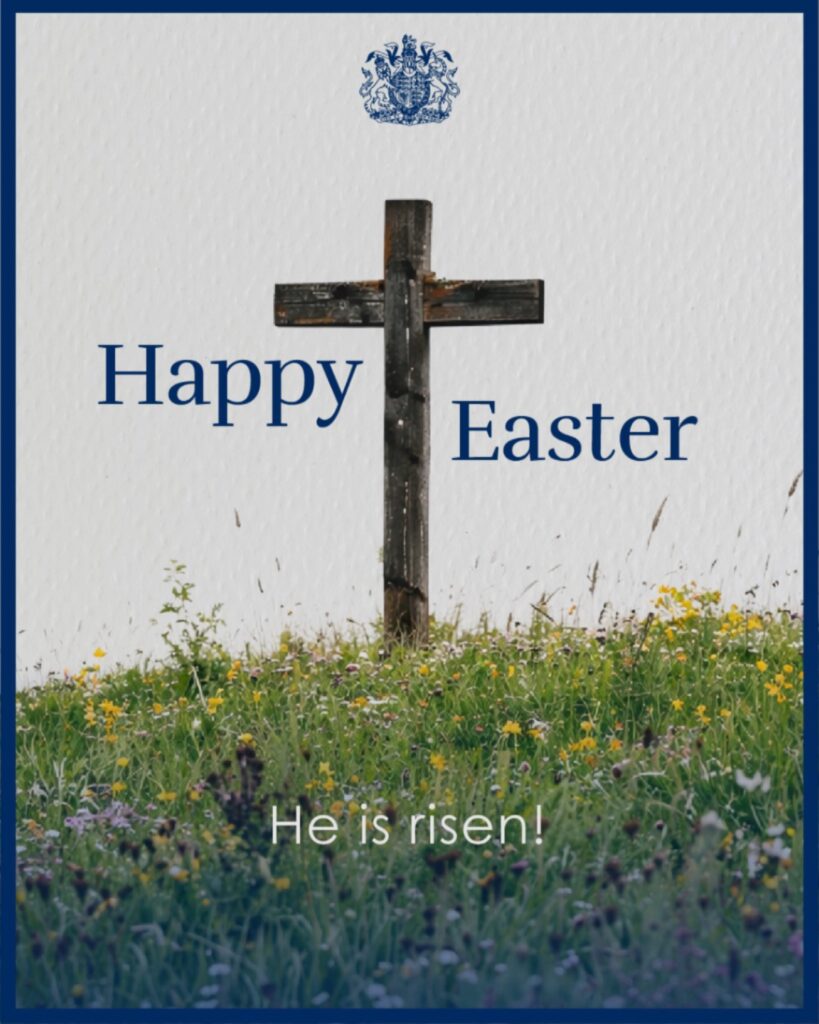 بطاقة تهنئة رسمية بـ عيد الفصح المجيد من جلالة الملك تشارلز الثالث لعام 2026، تظهر صليباً خشبياً يتوسط تلة خضراء مزهرة بالزهور البرية، مع شعار المملكة المتحدة في الأعلى وعبارة "Happy Easter" و "He is risen!".
