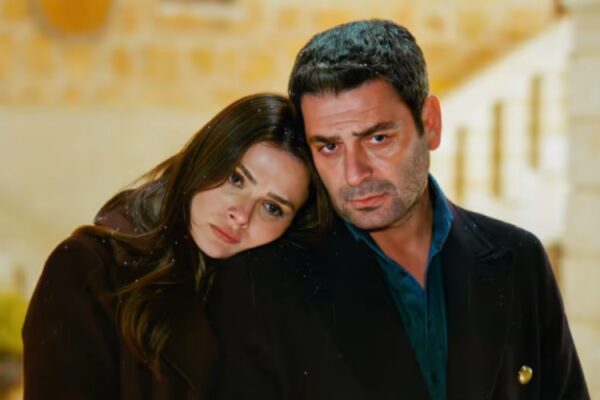 لقطة مقربة تجمع بين أوزان أكبابا وسينام أونسال في مشهد شتوي تكسوه ملامح الحزن، حيث تسند علياء رأسها على كتف جيهان وسط تساقط خفيف للثلوج، تعبيراً عن الصراع الإنساني ضمن أحداث مسلسل المدينة البعيدة في مدينة ماردين لعام 2026.