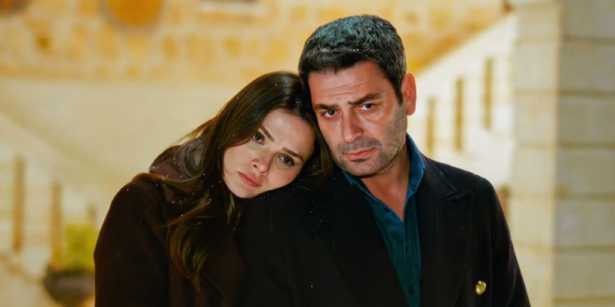 لقطة مقربة تجمع بين أوزان أكبابا وسينام أونسال في مشهد شتوي تكسوه ملامح الحزن، حيث تسند علياء رأسها على كتف جيهان وسط تساقط خفيف للثلوج، تعبيراً عن الصراع الإنساني ضمن أحداث مسلسل المدينة البعيدة في مدينة ماردين لعام 2026.