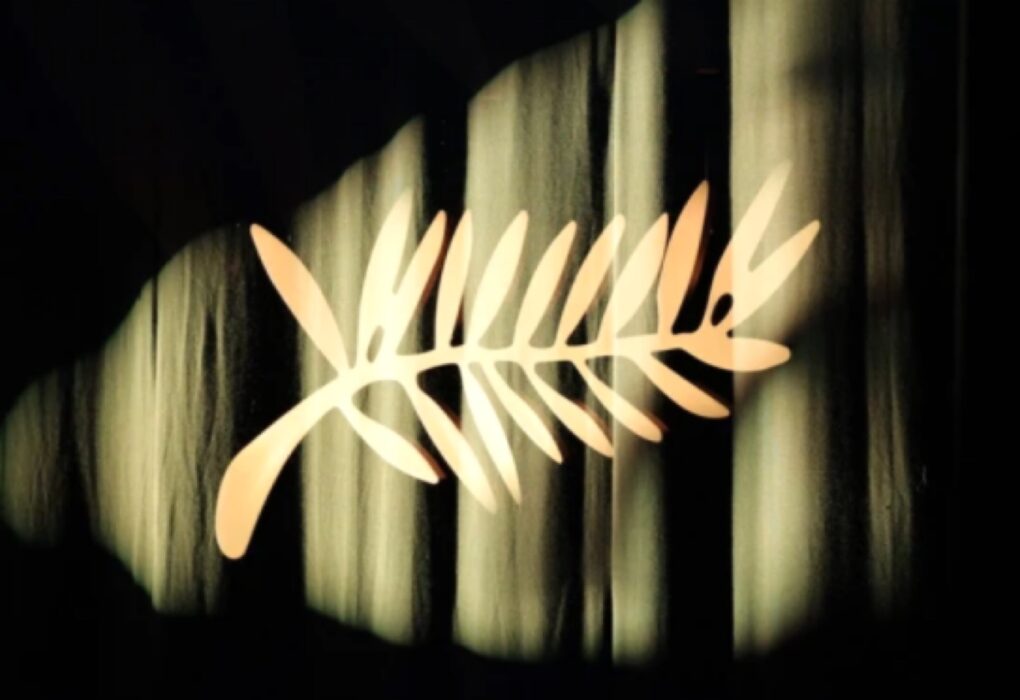 شعار سعفة ذهبية مضاءة بوضوح على خلفية من ستائر مخملية داكنة، ترمز لافتتاح فعاليات مهرجان كان السينمائي الدولي 2026.