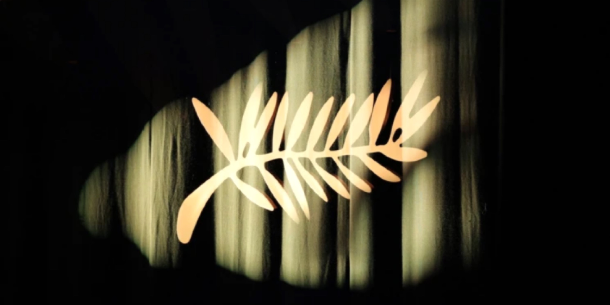 شعار سعفة ذهبية مضاءة بوضوح على خلفية من ستائر مخملية داكنة، ترمز لافتتاح فعاليات مهرجان كان السينمائي الدولي 2026.