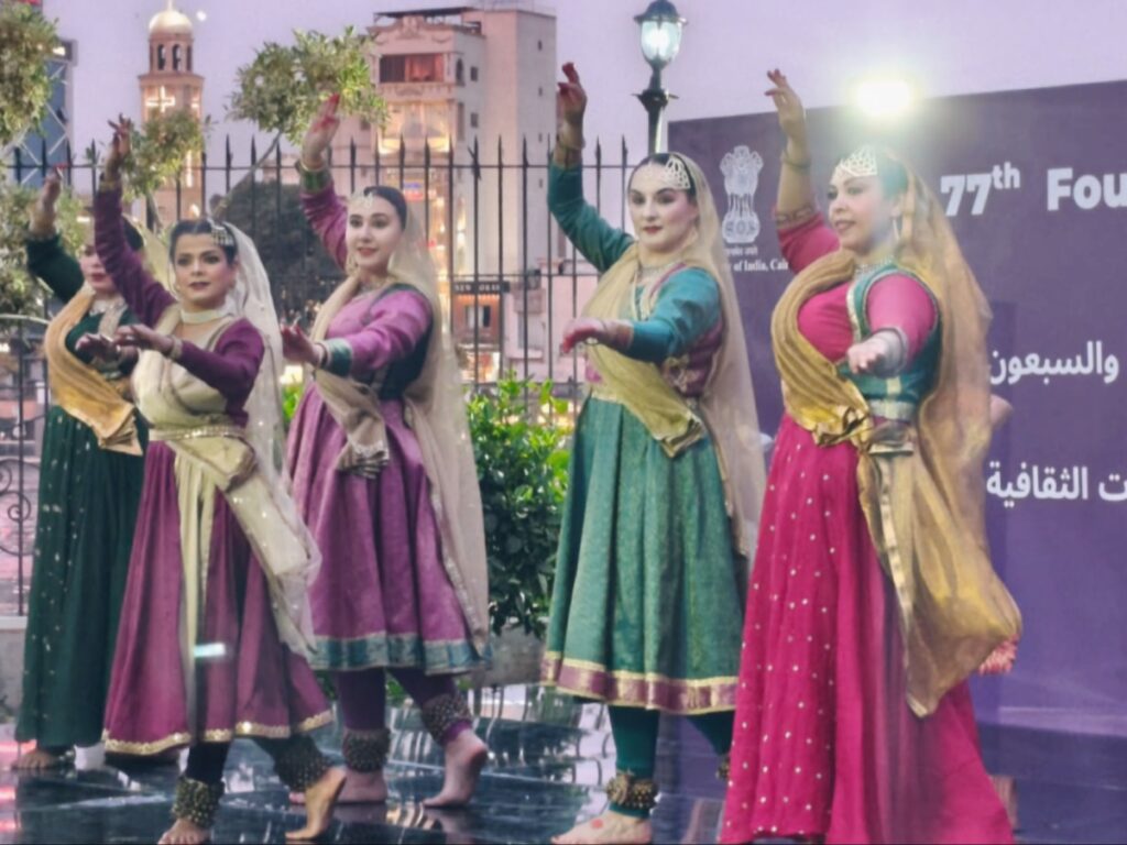 لافتة أرجوانية زاهية تعرض راقصات تقليديات هنديات وآلات موسيقية مثل السيتار والتابلا، مع نص باللغة العربية والإنجليزية حول "يوم تأسيس المجلس الهندي للعلاقات الثقافية" (الذكرى السابعة والسبعين).