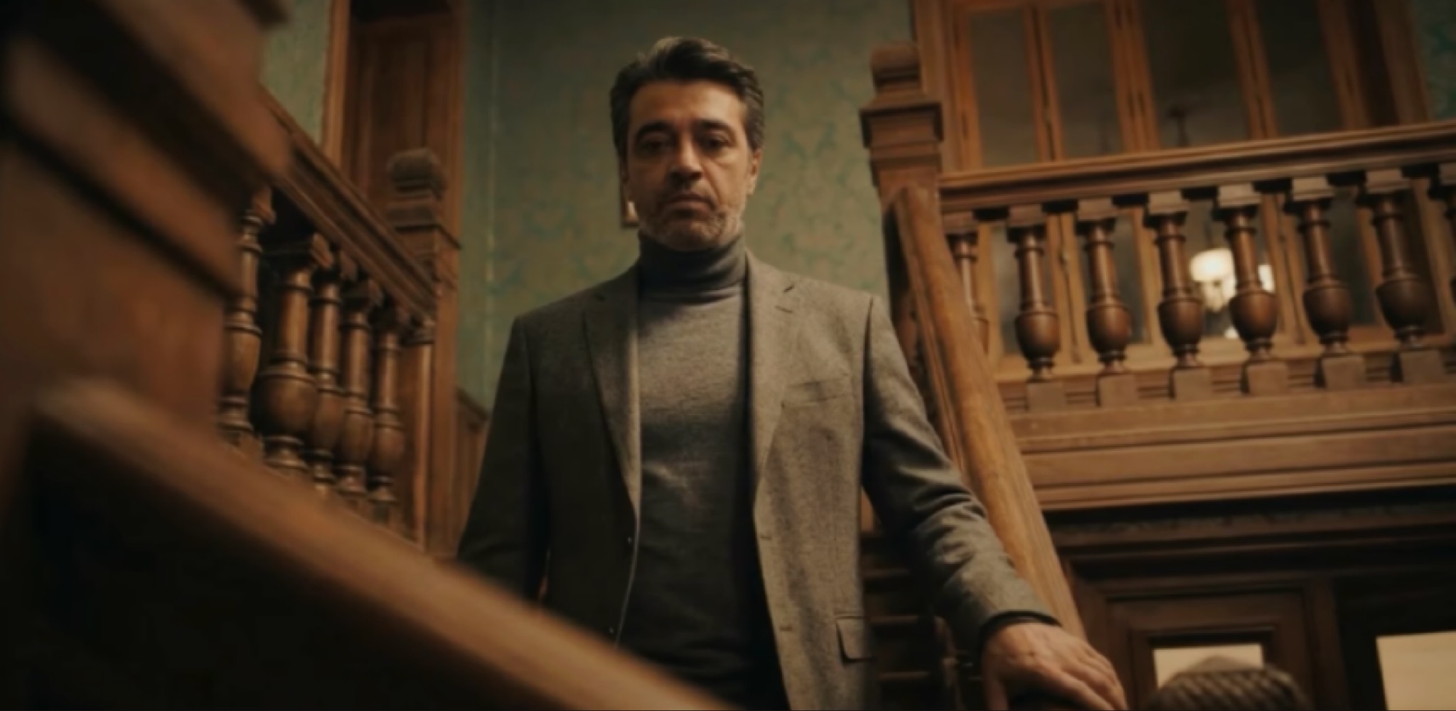 الفنان عصام كمال يقف على درج خشبي في مشهد من كليب أغنية ويعني لو.