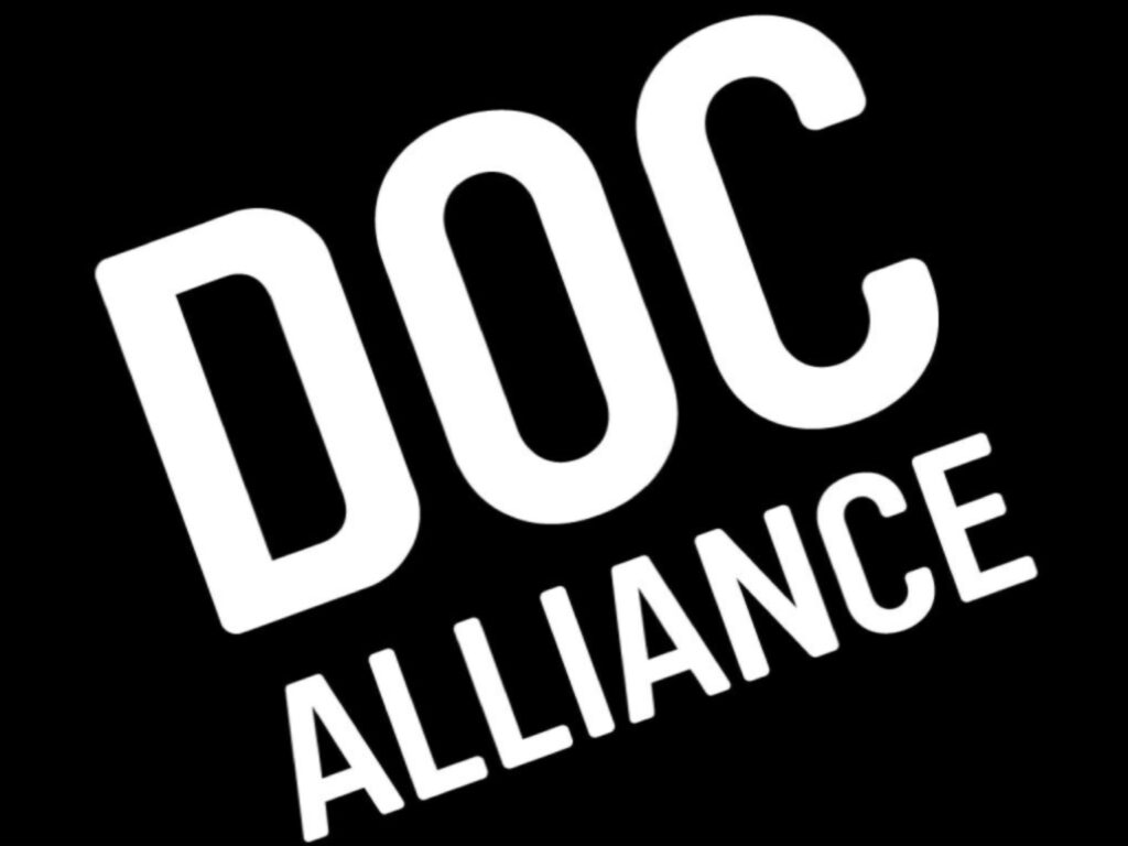 شعار تحالف "DOC ALLIANCE" الرسمي المائل باللون الأبيض، وهو الشعار المعتمد لـ جائزة Doc Alliance Award 2026.