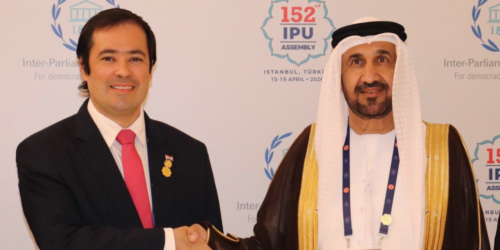 صورة عرضية مجمعة رفيعة المستوى تضم على اليسار محمد بن أحمد اليماحي، رئيس البرلمان العربي، وعلى اليمين رئيس برلمان "الميركوسور" في handshake، مع شعار البرلمان العربي و "152 IPU ASSEMBLY" بوضوح على خلفية LED.