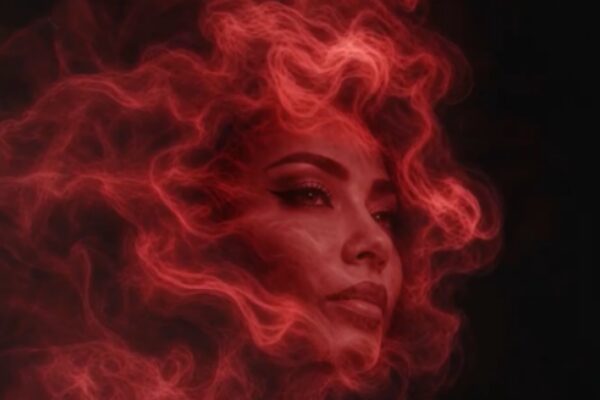 صورة فنية قريبة لوجه الفنانة شيرين عبد الوهاب، محاطة بهالة كثيفة من الدخان الأحمر الناري المتصاعد على خلفية سوداء.