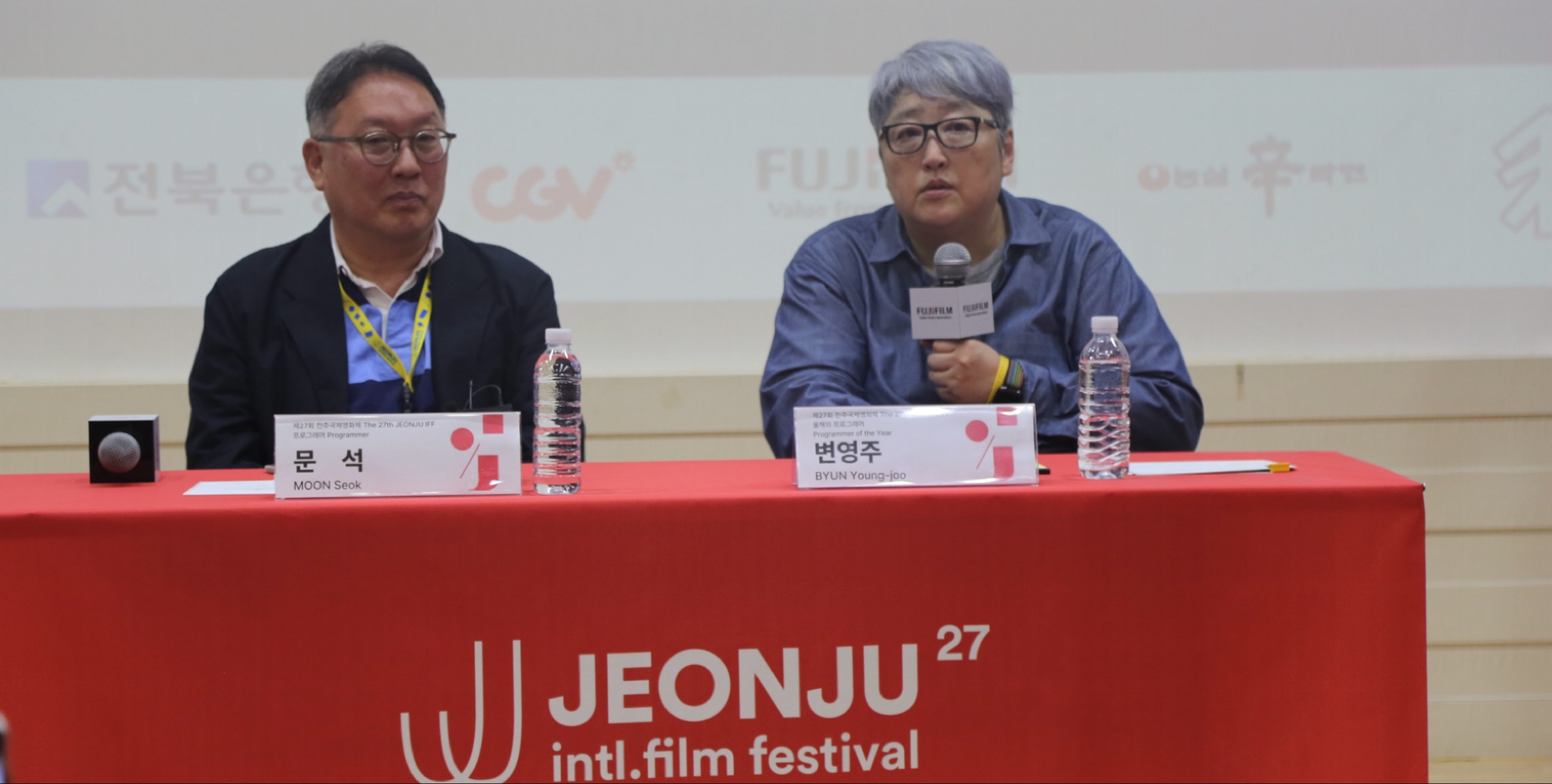 المخرجة بيون يونغ جو تتحدث عبر الميكروفون وإلى جوارها المبرمج مون سيوك خلال المؤتمر الصحفي لقسم مبرمج العام في مهرجان جونجو السينمائي الدولي، تصوير بلاك كات 24.