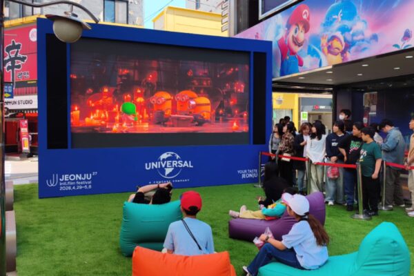 جمهور وعائلات يستمتعون بمتابعة عروض مهرجان جونجو السينمائي في الهواء الطلق عبر شاشة يونيفرسال.