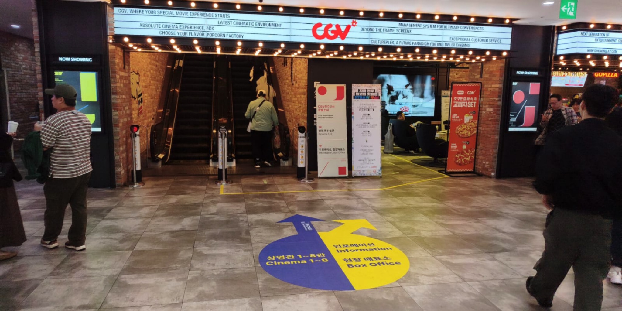 لقطة لمدخل سينما CGV بمدينة جونجو تظهر اللوحات الإرشادية الأرضية والملصقات الترويجية لزوار مهرجان جونجو السينمائي الدولي. عدسة بلاك كات 24.