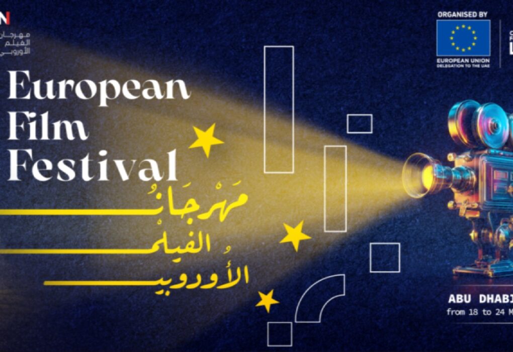 ملصق دعائي لمهرجان الفيلم الأوروبي - الإمارات 2026. يظهر على اليسار مبنى تاريخي إماراتي مضاء ونخلة واحدة. في الوسط، تحت شعاع ضوئي أصفر قادم من كاميرا سينمائية عتيقة على اليمين، يظهر نص كبير باللغتين الإنجليزية والعربية: "European Film Festival" و "مهرجان الفيلم الأوروبي". الخلفية زرقاء داكنة مع نجوم ورموز خطية بيضاء.