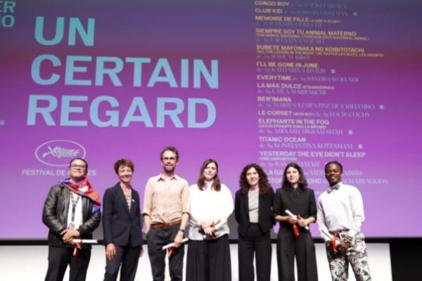 صورة جماعية للفائزين بجوائز مسابقة Un Certain Regard يقفون على خشبة المسرح حاملين شهادات التكريم أمام شاشة بنفسجية عملاقة تعرض أسماء الأفلام المشاركة