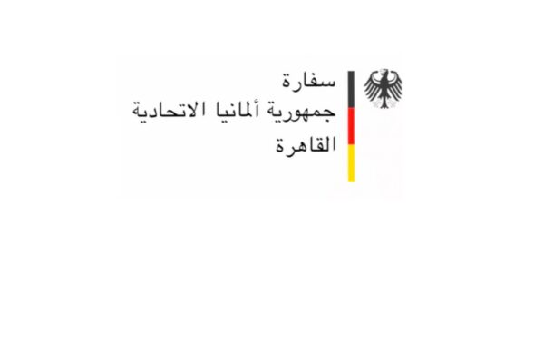 شعار رسمي يمثل السفارة الألمانية بالقاهرة، يتضمن النص العربي "سفارة جمهورية ألمانيا الاتحادية القاهرة" بجوار النسر الألماني الأسود، وخط عمودي بألوان العلم الألماني الأسود والأحمر والأصفر على خلفية بيضاء.