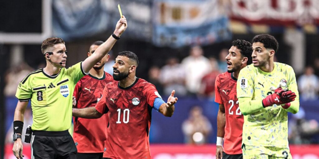 حكم يشهر البطاقة الصفراء وسط اعتراض لاعبي المنتخب الوطني المصري خلال مباراة مصر والأرجنتين