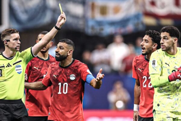 حكم يشهر البطاقة الصفراء وسط اعتراض لاعبي المنتخب الوطني المصري خلال مباراة مصر والأرجنتين