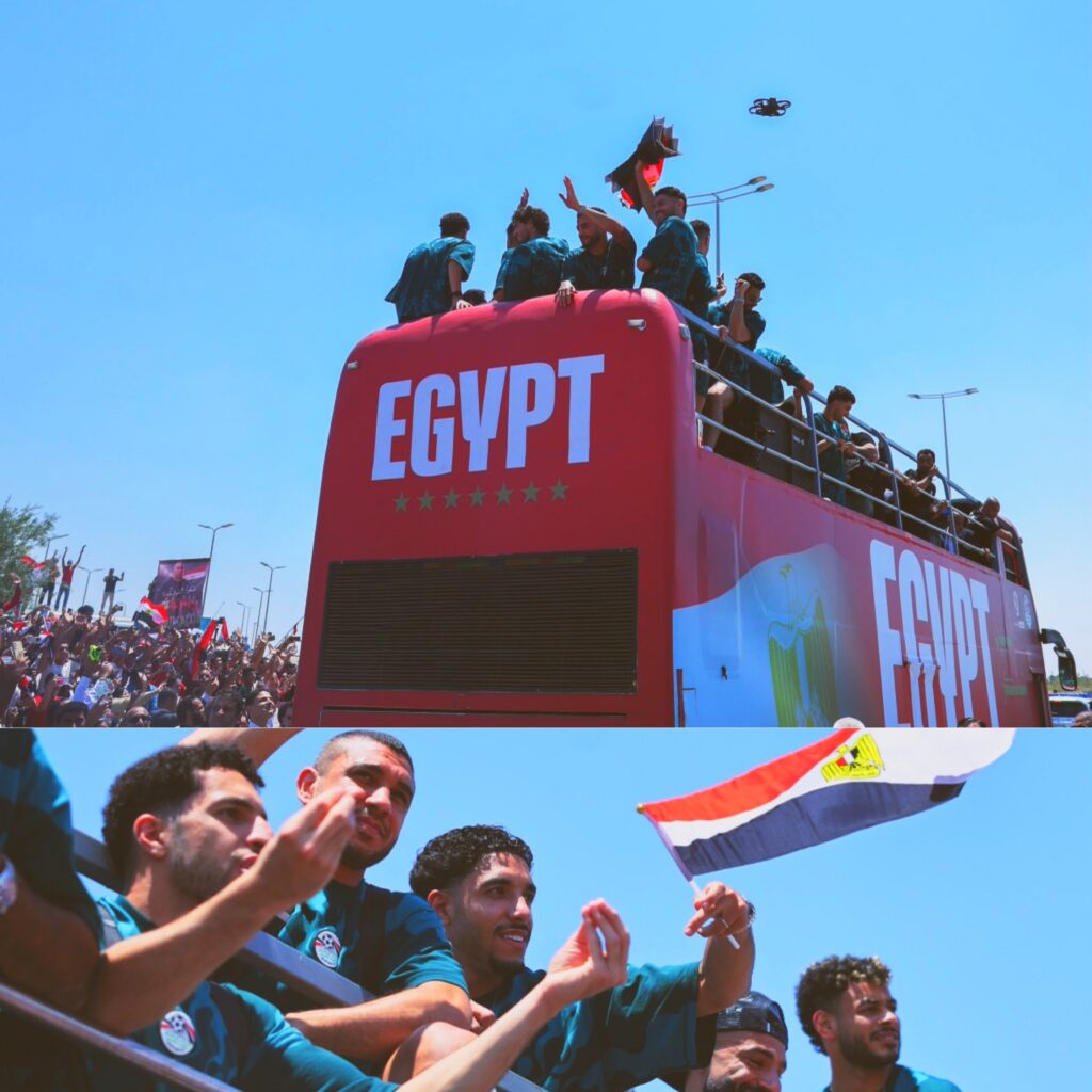 لاعبو بعثة المنتخب الوطني المصري يحتفلون مع الجماهير على متن حافلة حمراء مكشوفة تحمل كلمة EGYPT ويرفعون العلم المصري