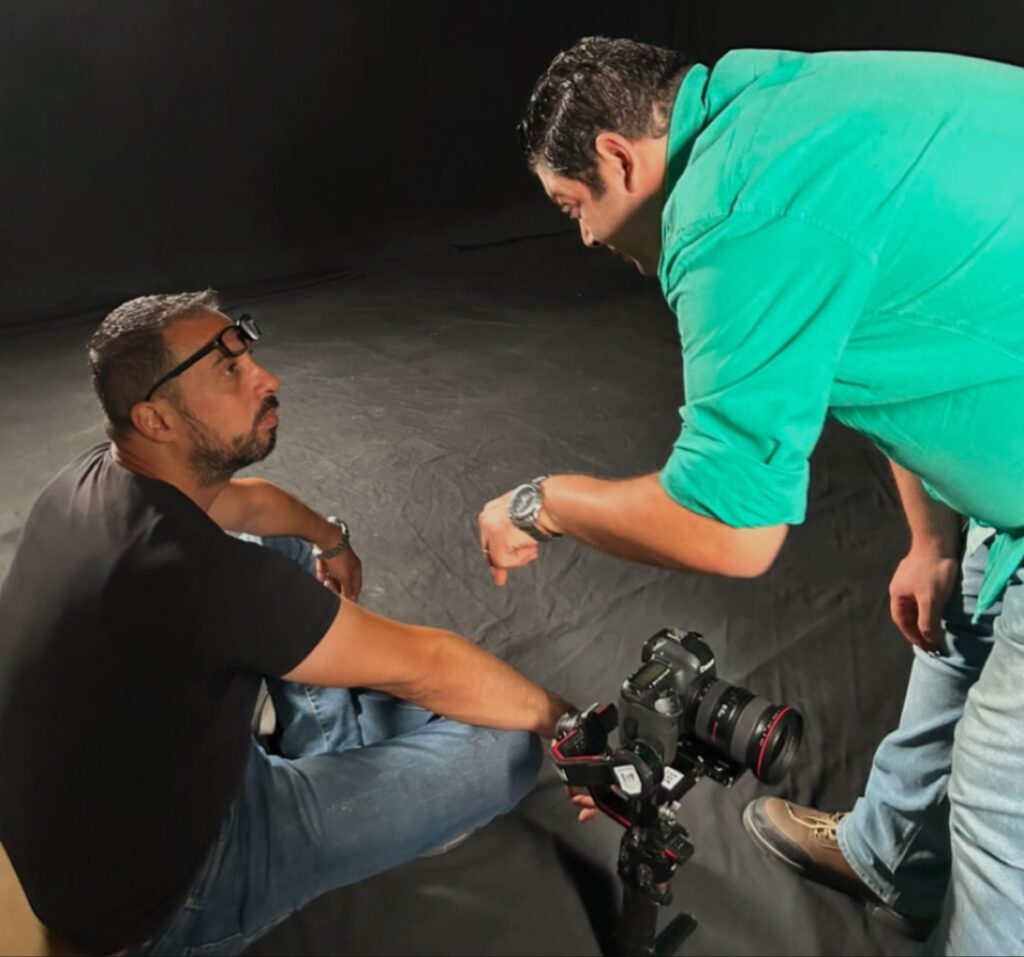 المخرج باهي سري يوجه مدير التصوير إبراهيم إمام الجالس على الأرض أثناء تصوير مشاهد الفيديو كليب