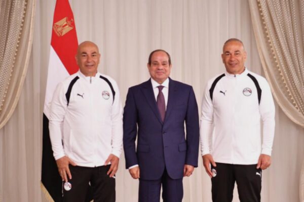 فخامة الرئيس عبد الفتاح السيسي يتوسط التوأم حسام وإبراهيم حسن بملابس رياضية أمام علم مصر خلال حفل تكريم المنتخب الوطني المصري
