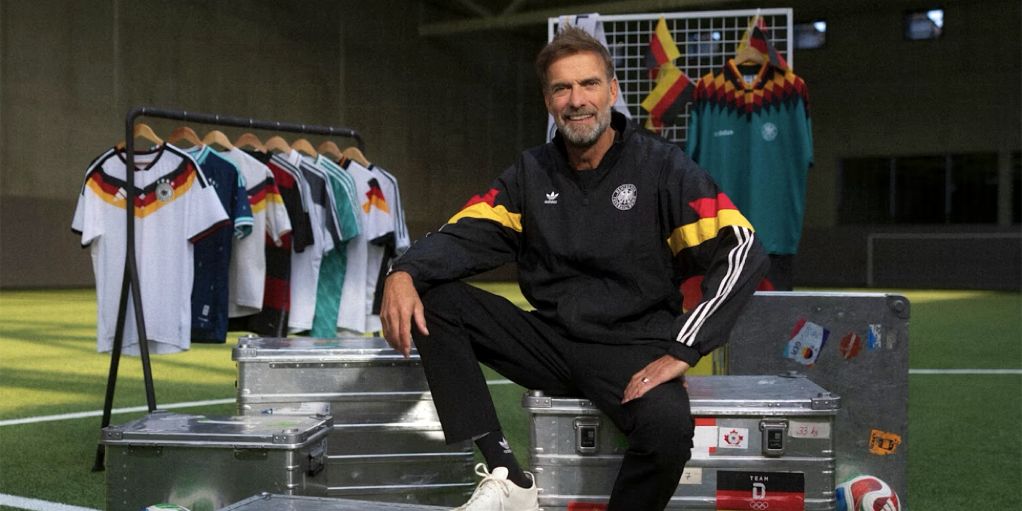 يورجن كلوب يرتدي الزي الرياضي للمنتخب وسط قمصان الفريق، تزامنا مع الإعلان الرسمي عن تعيين يورجن كلوب مدربا لألمانيا