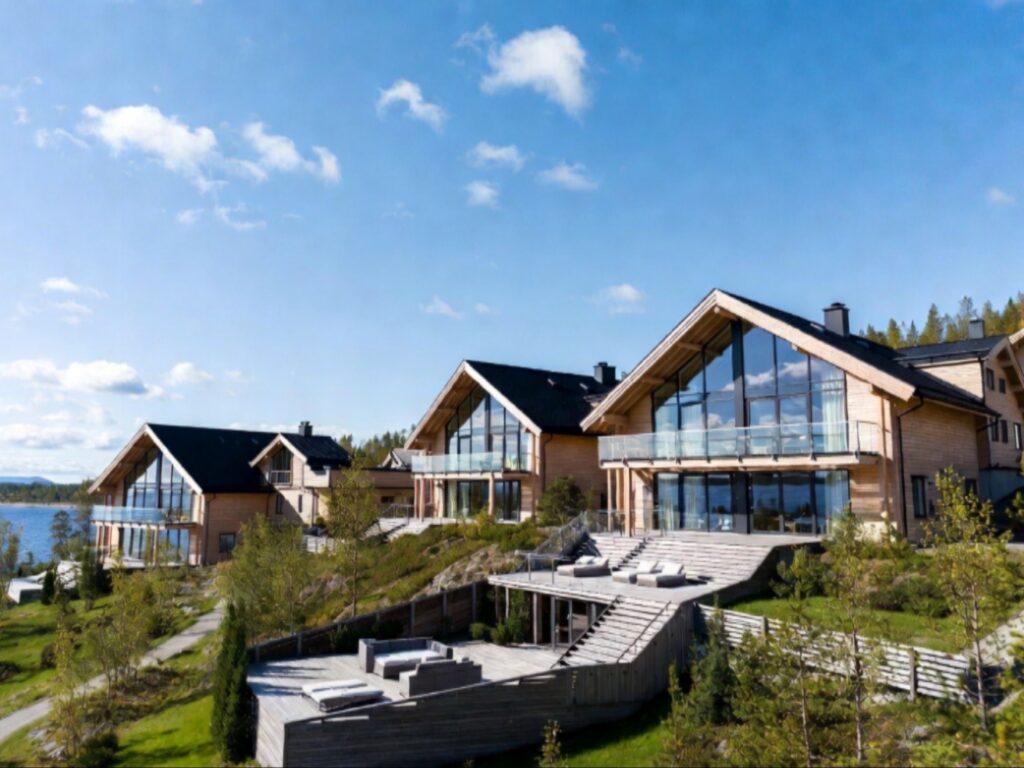 فيلات خشبية حديثة بنوافذ زجاجية كبيرة تطل على المياه، تمثل خيارات راقية ضمن الإقامة في لابلاند الفنلندية