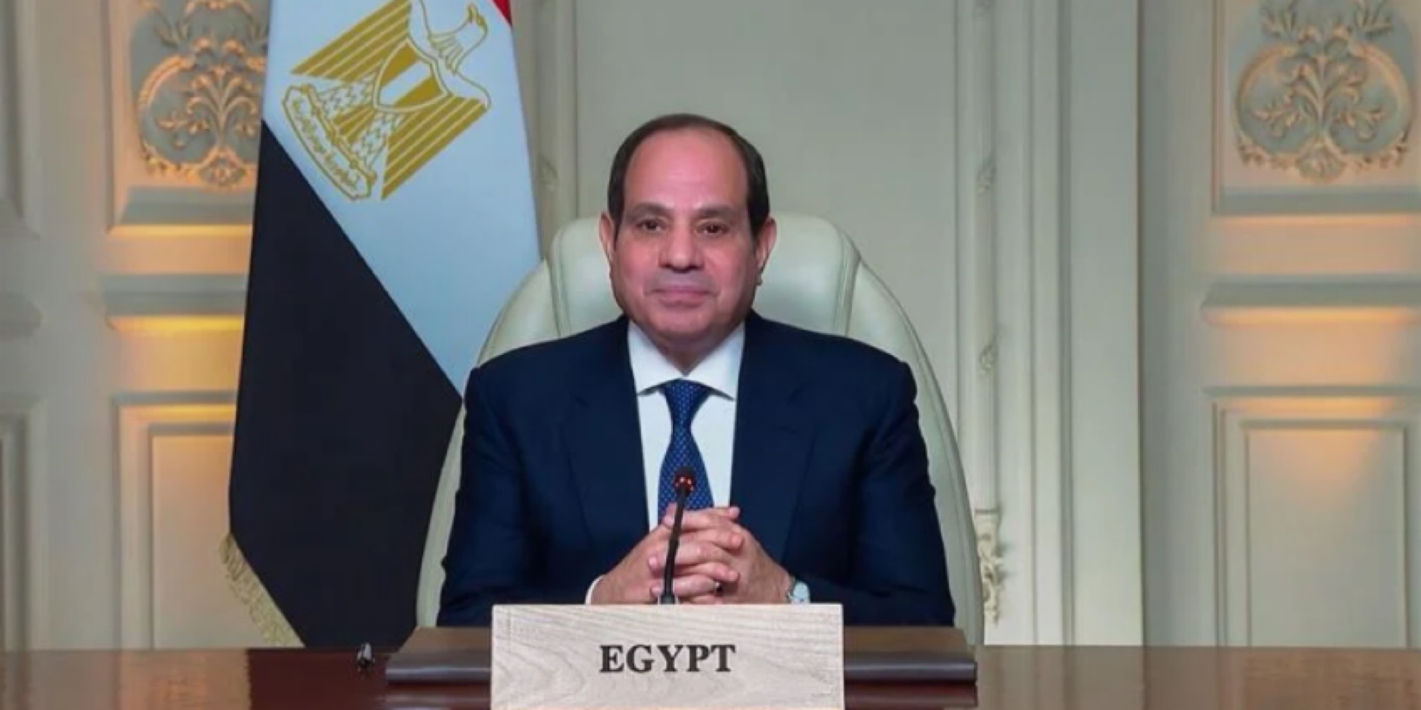 فخامة الرئيس عبد الفتاح السيسي يتحدث من خلف مكتب يحمل لافتة باسم مصر باللغة الإنجليزية (EGYPT)، وبجواره علم جمهورية مصر العربية، أثناء إلقاء كلمته الافتتاحية في الدورة التاسعة من أسبوع القاهرة للمياه